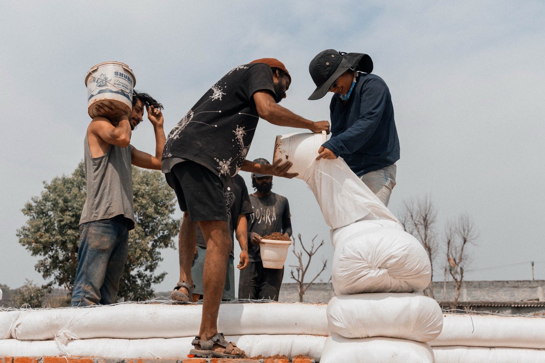 Filling earthbags for the walls